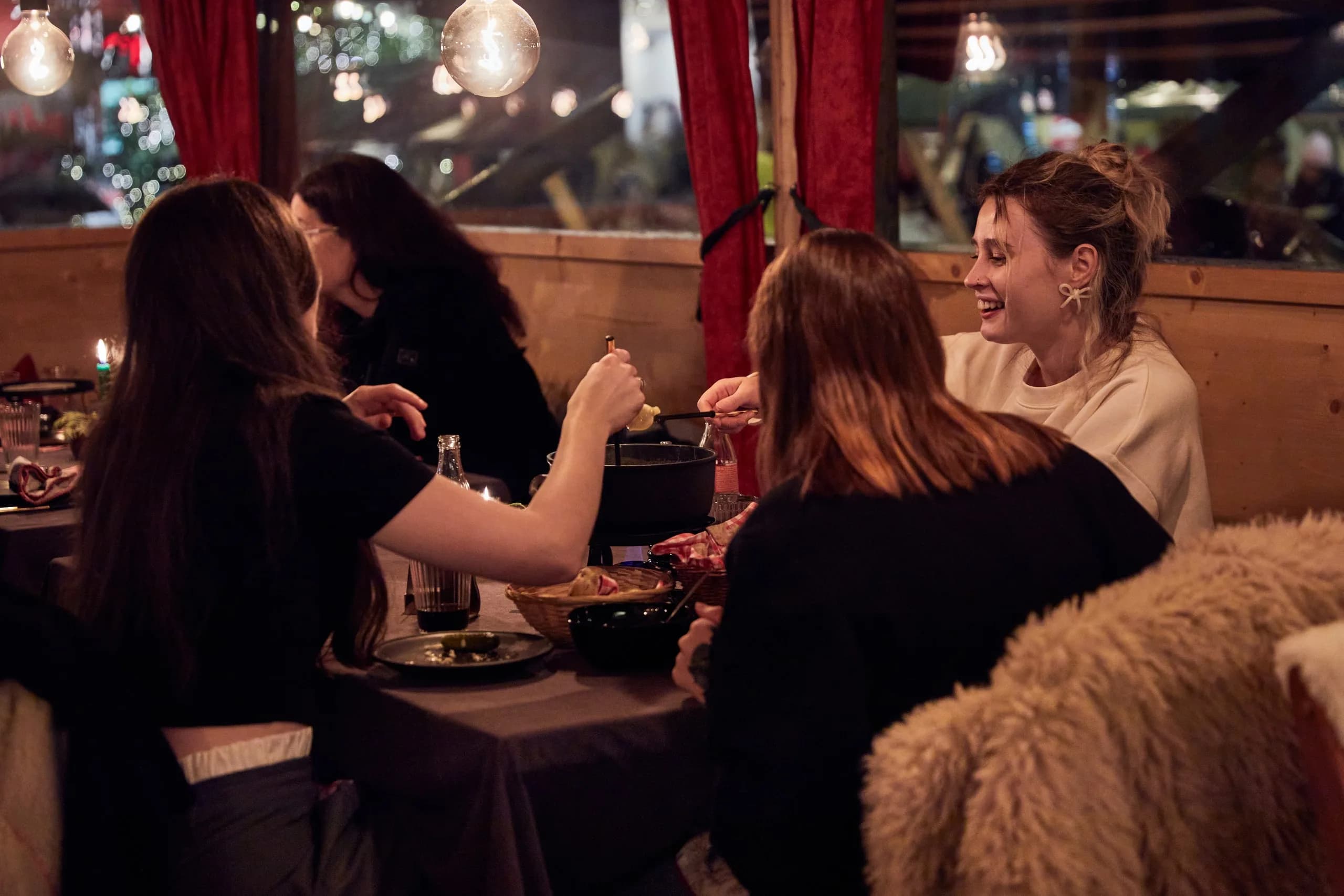 Freundinnen teilen ein Caquelon im Fondue Chalet am Wiehnachtsmärt Zürich