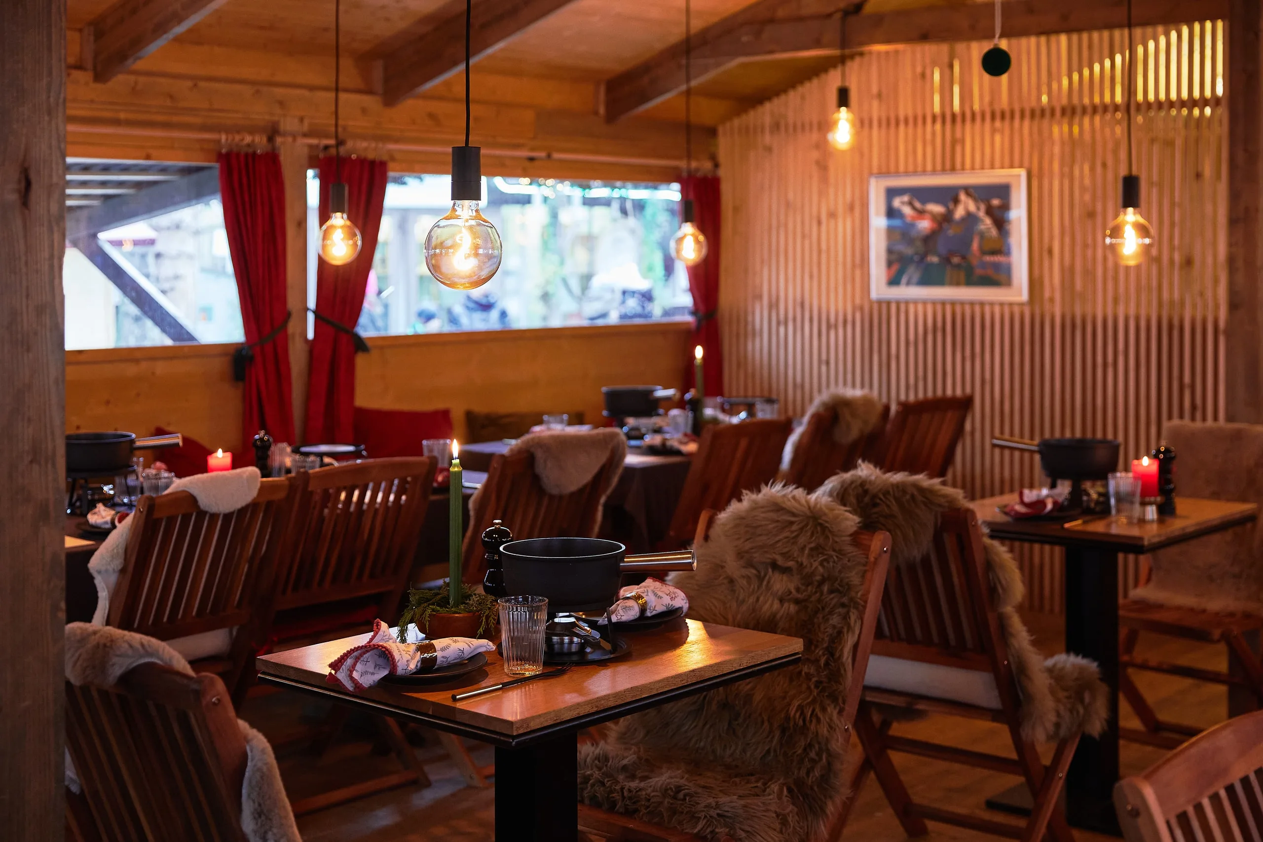 Gedeckte Tische mit Caquelon, Kerzen und Fellen im Fondue Chalet am Werdmühleplatz in Zürich