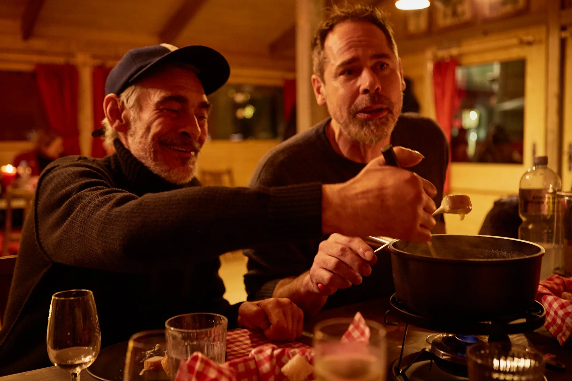 Zwei Gäste tunken Brot ins Käsefondue im Fondue Chalet Zürich