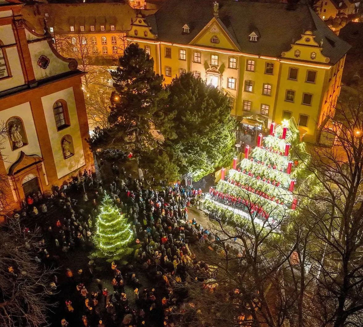 Veduta aerea di Waldkirch: Singing Christmas Tree illuminato con coro, pubblico davanti fra edifici barocchi