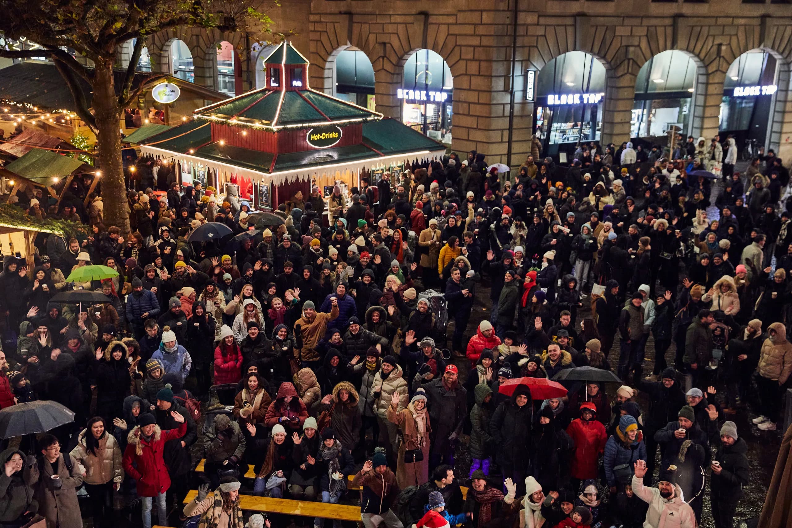 Pubblico fitto sul Werdmühleplatz fra il padiglione delle bevande calde e le casette del mercatino, molti salutano